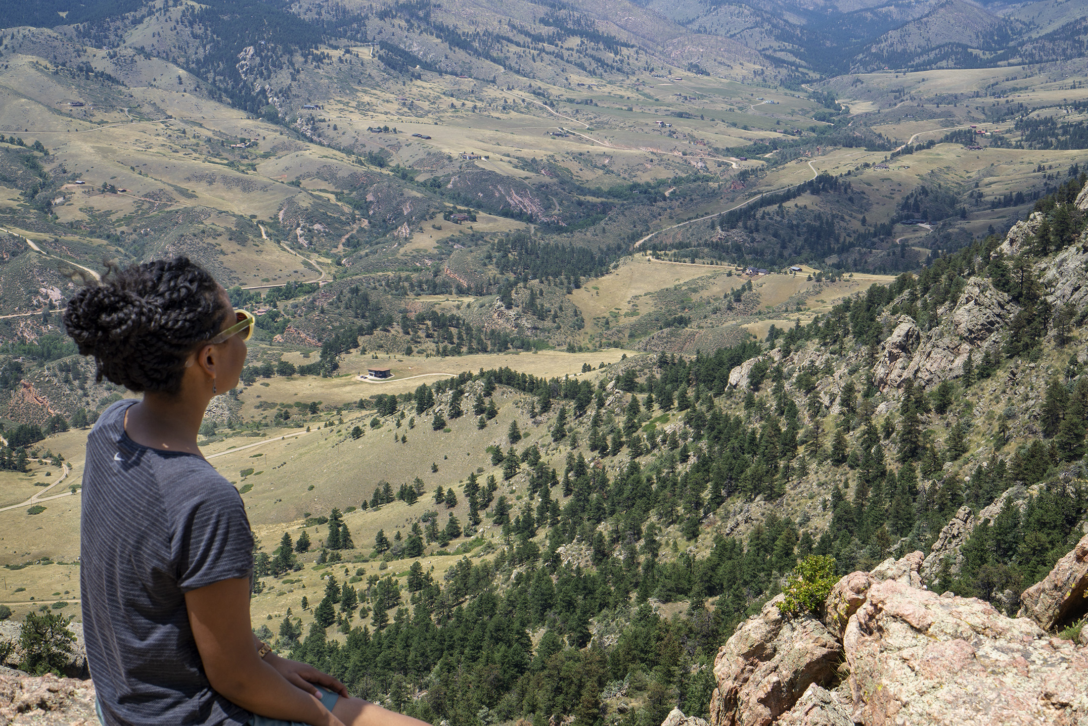 Black woman looking out onto valley from top of Horsetooth Rock, Colorado / Darker than Green